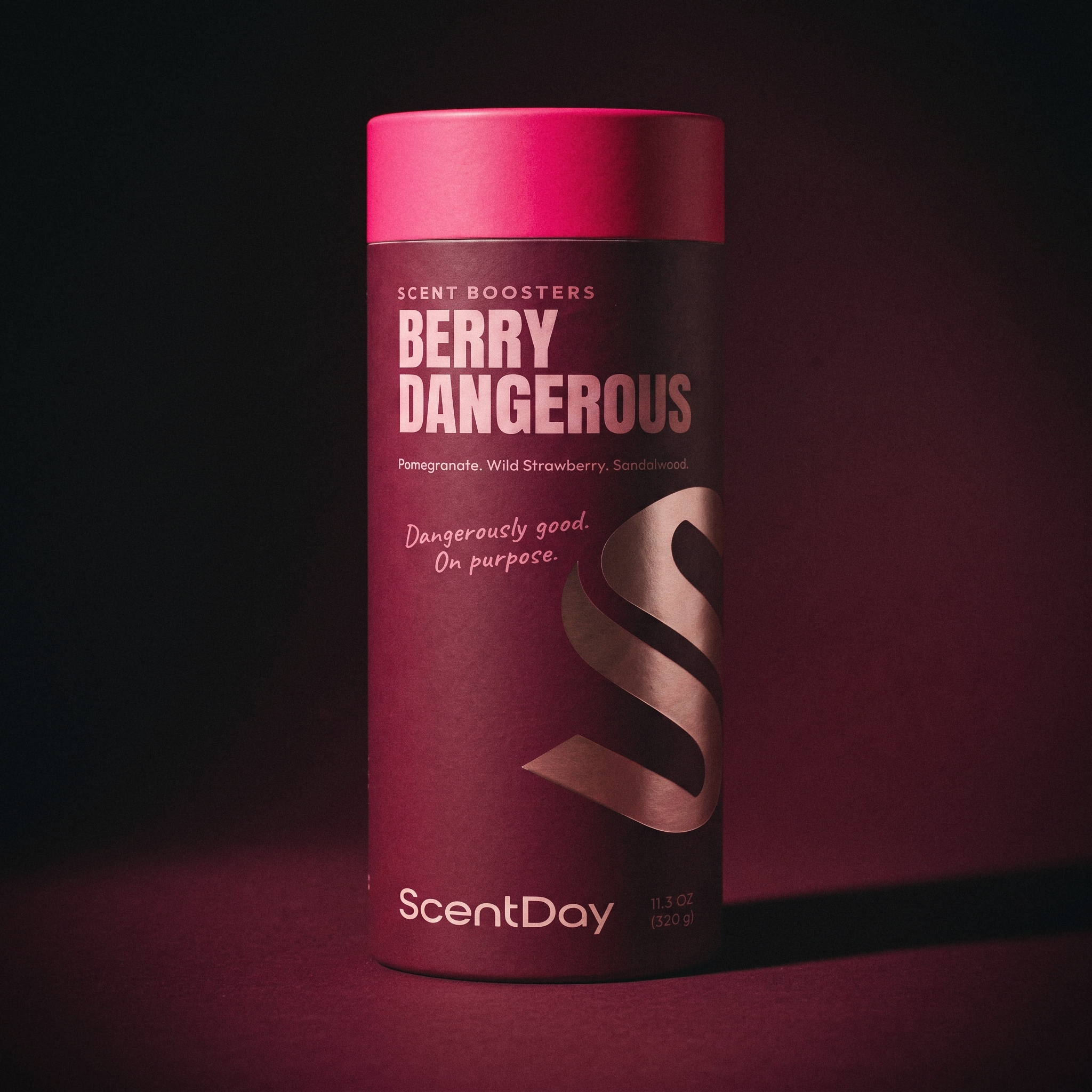 ScentDay Berry Dangerous scent booster in a dark burgundy studio scene with pomegranate and sandalwood