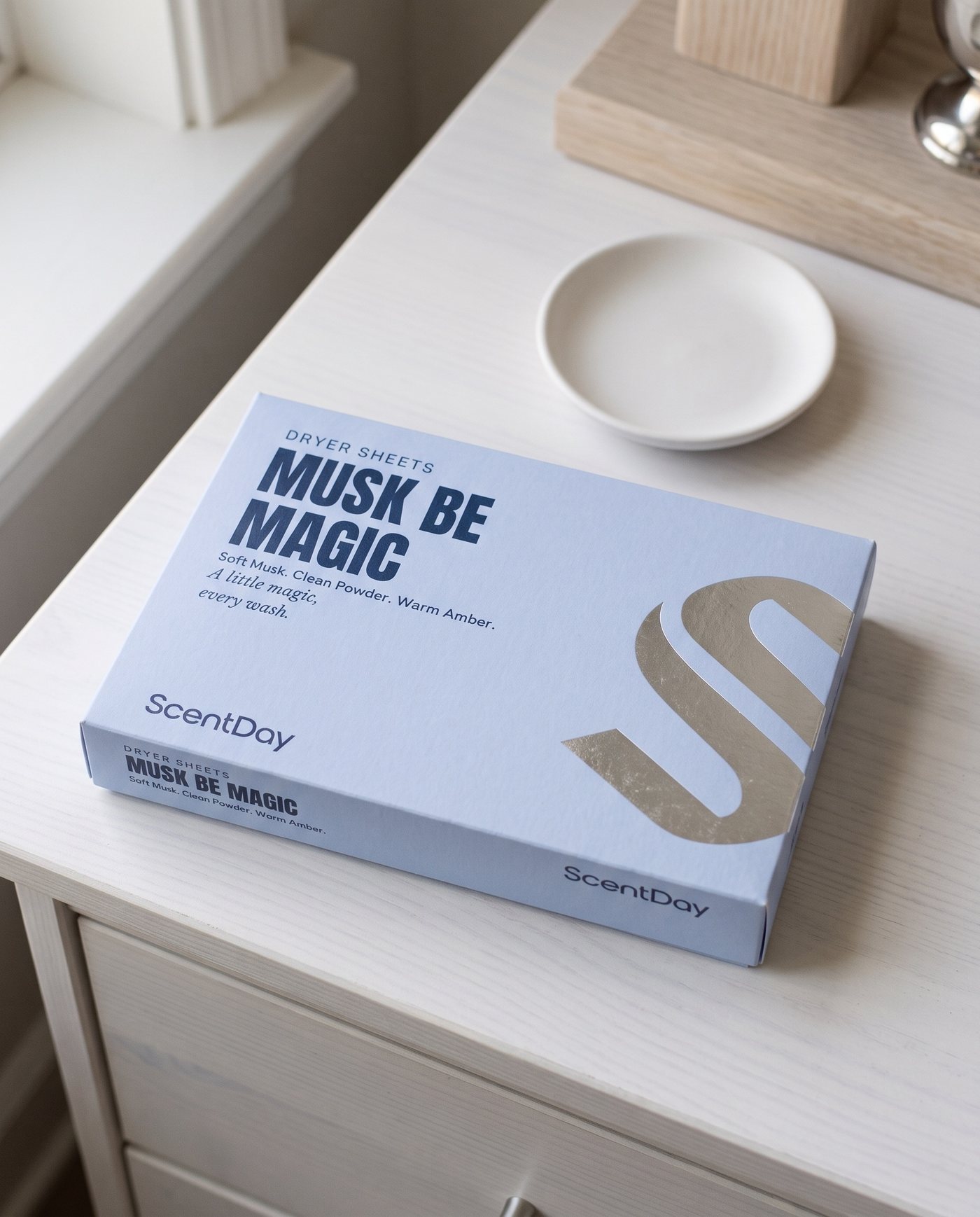 Musk be Magic dryer sheets box on a white painted dresser in soft morning light