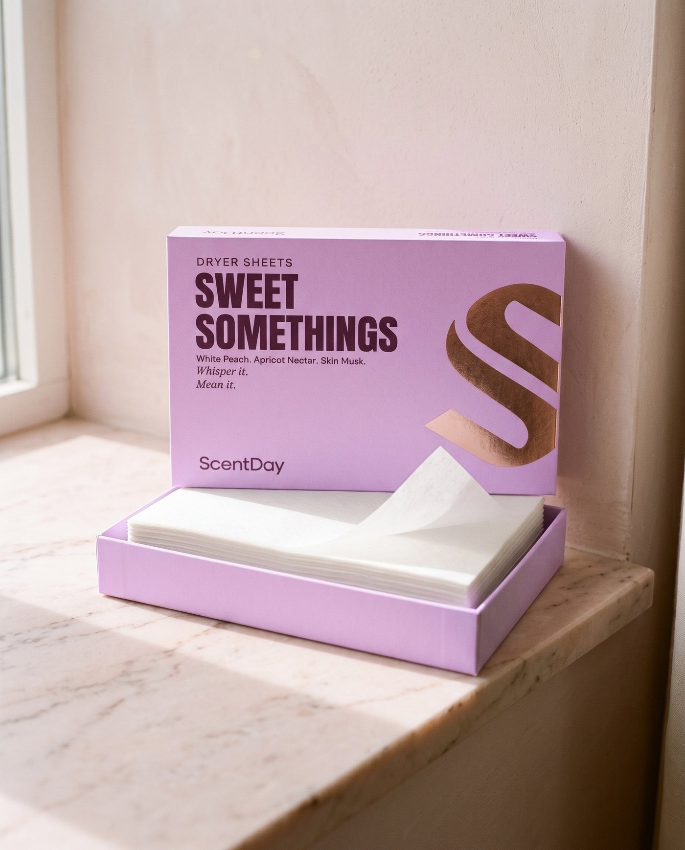 Open Sweet Somethings dryer sheets box with a stack of white dryer sheets